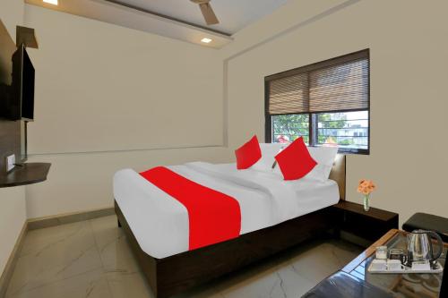 1 dormitorio con 1 cama grande con almohadas rojas en Flagship Nandi Palace Lodging And Boarding, en Bombay