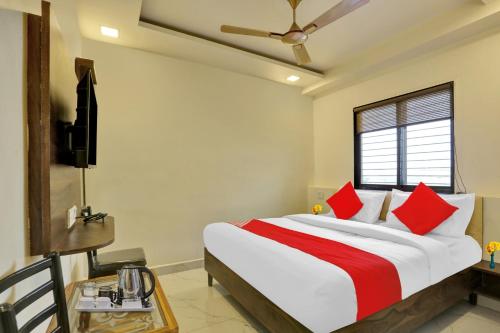 a bedroom with a large bed with red pillows at Flagship Nandi Palace Lodging And Boarding in Mumbai