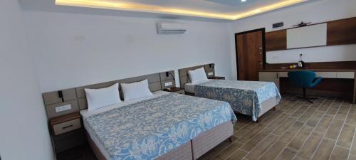 a hotel room with two beds and a desk at Kaptanhan Pansiyon in Kazıklı
