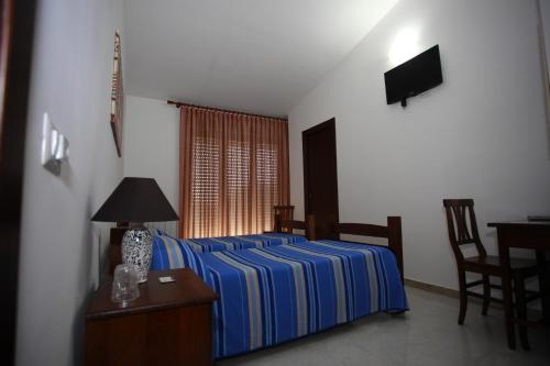 a bedroom with a bed and a table and a television at Sicily Bike di Fina Rosario in Serradifalco