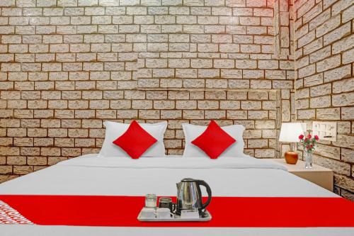 um quarto com uma cama com almofadas vermelhas e brancas em Flagship Lemon Tree Inn em Rāipur