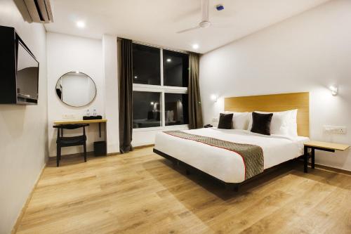 a bedroom with a bed and a large window at Super townhouse moosapet Rcc Prime in Hyderabad