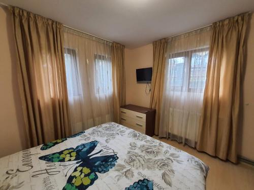 - une chambre avec un lit doté d'un couvre-lit fleuri dans l'établissement Апартамент Зимна приказка, à Chepelare