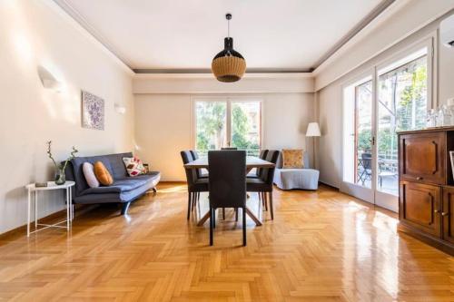 Spacious renovated flat in the Athens Riviera في أثينا: غرفة طعام وغرفة معيشة مع طاولة وكراسي