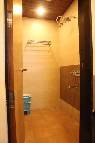 a small bathroom with a toilet and a shelf at Hotel Grand Ecotel, Aurangabad in Aurangabad