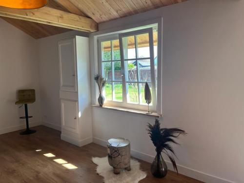 um quarto com uma janela com dois pássaros sentados na parede em Het Buitenleven em Spaarndam
