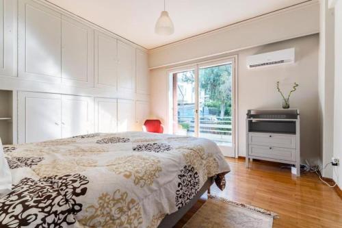 Spacious renovated flat in the Athens Riviera في أثينا: غرفة نوم بسرير كبير ونافذة