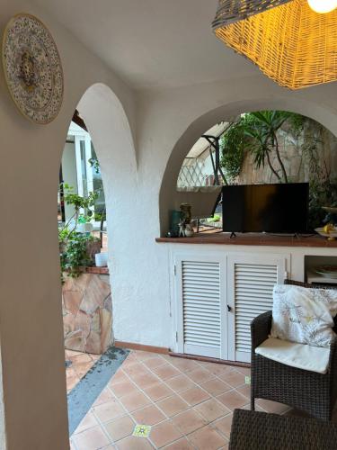 a living room with an archway and a television at Maison Mele Ischia in Ischia