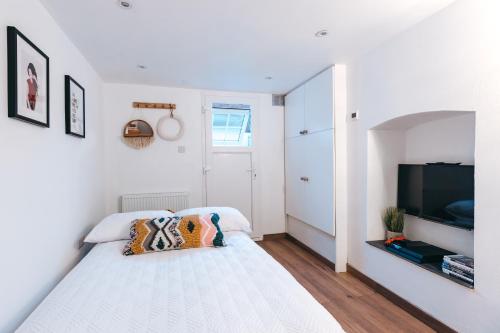 um quarto branco com uma cama e uma televisão de ecrã plano em The Maltings em Shrewsbury
