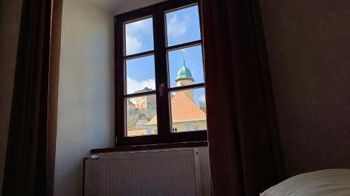 a window in a bedroom looking out at a church at Apartmány Javorník in Javorník