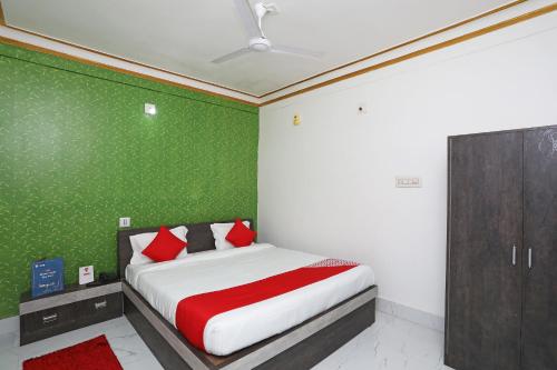 a bedroom with a bed with a green wall at OYO Aradhya Residency in Bhubaneshwar