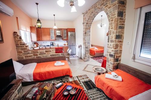 a living room with two beds and a kitchen at DAFNI'S HOME in Volos