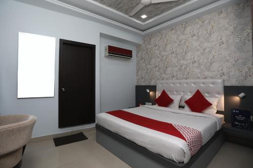 um quarto com uma cama com almofadas vermelhas e uma janela em Flagship Hotel Mangalam Inn em Izatnagar