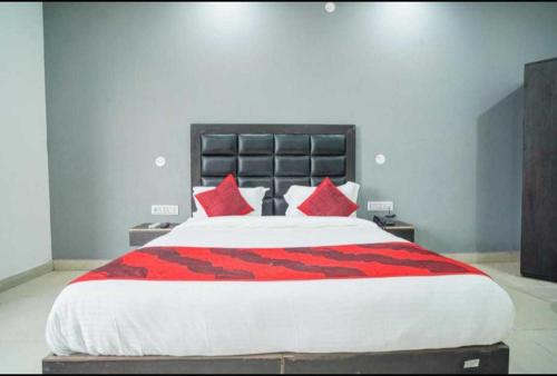 a bedroom with a large bed with red pillows at POP Hotel Pingal Dream Near Prachin Shani Mandir Near Dashrath Puri Metro Station in New Delhi