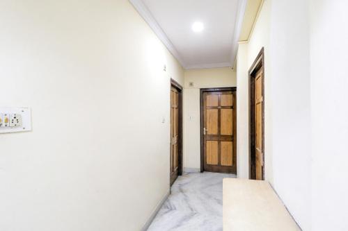um corredor com paredes brancas e uma porta em SPOT ON Hotel Sanskriti em Nagpur