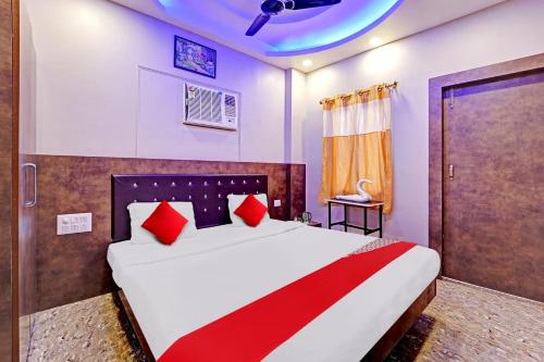 a bedroom with a large bed with red pillows at Flagship Saharsh Hotel in Patna
