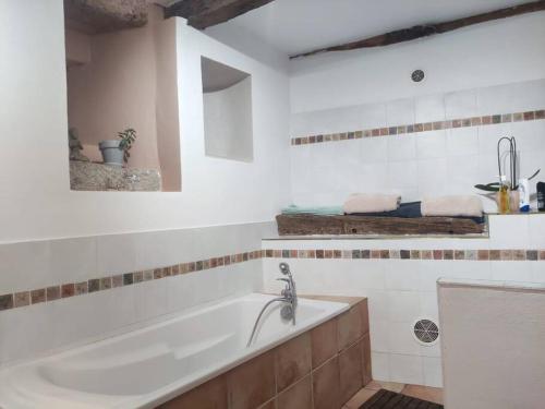 une salle de bain blanche avec une baignoire et un lavabo dans l'établissement Grande bastide vue magnifique. Piscine intérieure., à Saint-Sauveur-de-Montagut