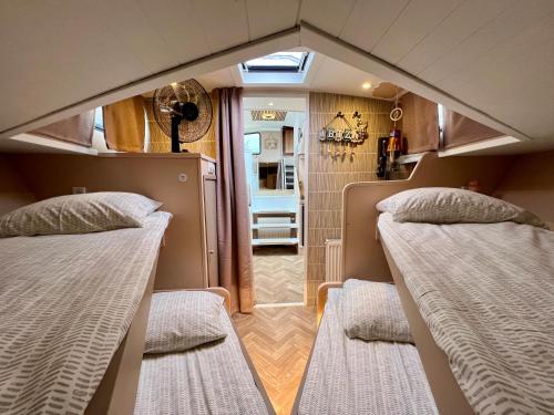 2 bedden in een kleine kamer met een badkamer bij NEW - LITTLE IBIZA, on a lake near Amsterdam, with HOT TUB! in Vinkeveen