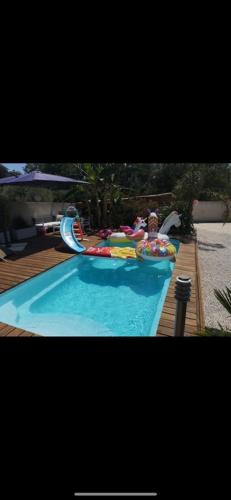 une grande piscine avec un toboggan aquatique dans l'établissement Madinina, à Bormes-les-Mimosas