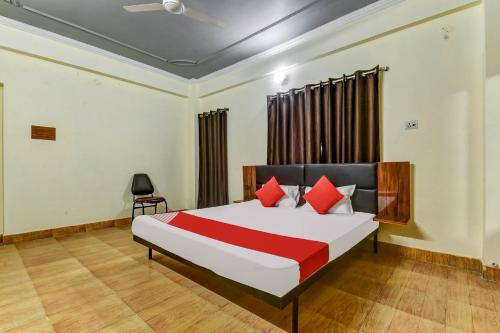1 dormitorio con 1 cama grande con almohadas rojas en Super OYO Olive Grand, en Patna