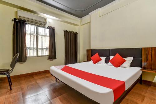 a bedroom with a large bed and a chair at Super OYO Olive Grand in Patna