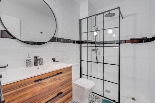 a bathroom with a toilet and a sink and a mirror at Sea Cocoon in Playa de las Americas