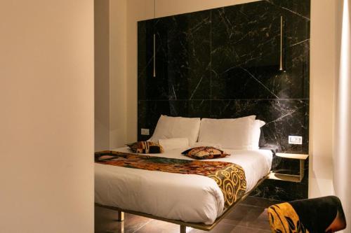 sypialnia z dużym łóżkiem z czarnym zagłówkiem w obiekcie Bhr Cavour 150 w Rzymie