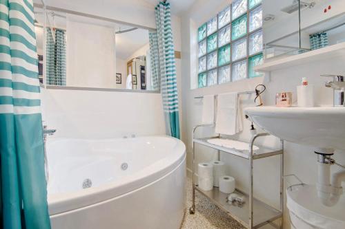 une salle de bain blanche avec une baignoire et un lavabo dans l'établissement Casa Armando, à Laglio