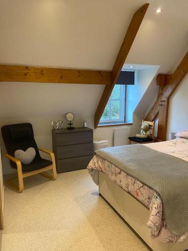 une chambre avec un lit et une chaise dans l'établissement Concombre Cottage, à Le Grais