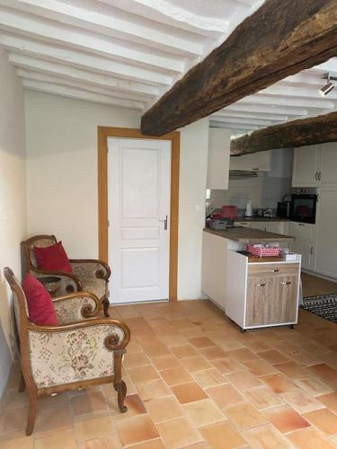 un salon avec une chaise et une cuisine dans l'établissement Concombre Cottage, à Le Grais
