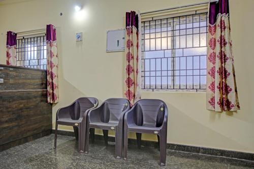 trzy krzesła w poczekalni z oknem w obiekcie Vsv Guest House w mieście Ćennaj