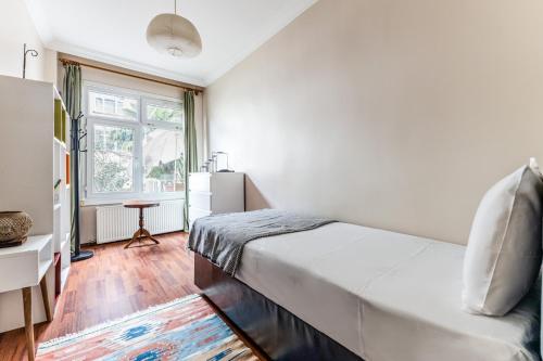 a white bedroom with a bed and a window at Modern Flat with Balcony in Uskudar in Istanbul