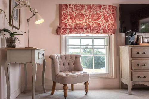a living room with a chair and a window at The Black Lion, Long Melford in Long Melford