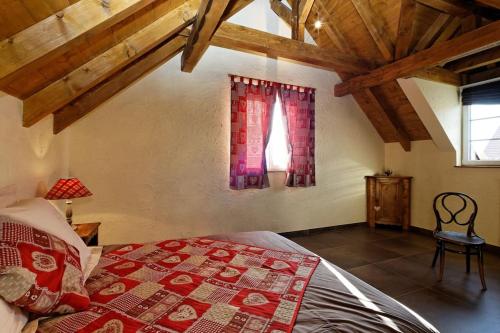 a bedroom with a bed with a red blanket and a window at Le gite 'Humulus' in Bilwisheim