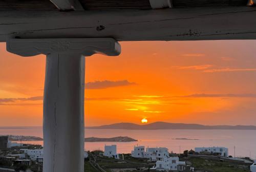 a sunset seen from the balcony of a building at Nomia Sunset Suites Mykonos in Tagou