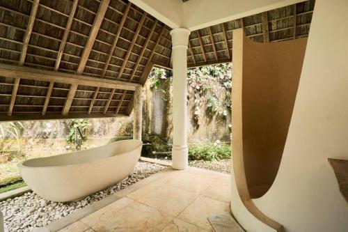 a bath tub in a bathroom with a window at Unique 3BR Villa with Pool 5 minute walk to the Pererenan beach in Canggu