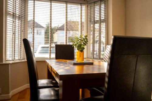 a table with a potted plant on it in front of a window at 3 BR House BHX HS2 Contractor Solihull FREE Parking in Sheldon