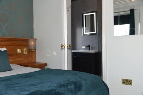 Ένα ή περισσότερα κρεβάτια σε δωμάτιο στο Greyhound Hotel