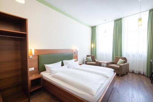フラインスハイムにあるAltstadthof Freinsheimのベッドルーム1室(大きな白いベッド1台、椅子2脚付)