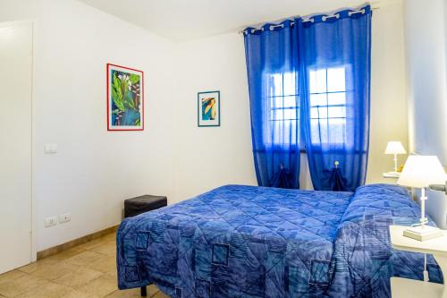 Un dormitorio con una cama azul y una ventana. en Casa Flavia - Castiglione, en Castiglione della Pescaia