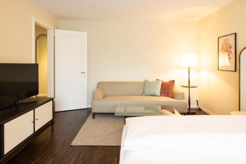 a hotel room with a bed and a couch at EMA House Serviced Apartments Superior Seefeld in Zürich