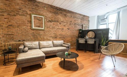 uma sala de estar com um sofá e uma parede de tijolos em STUNNING Old Port lofts em Montreal
