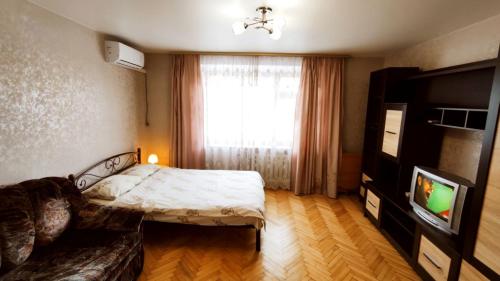 1 dormitorio con 1 cama y TV en KyivStay Vvedenska Apartment, en Kiev