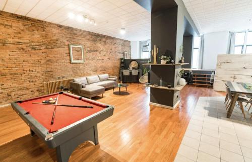 um quarto com uma mesa de pingue-pongue e uma parede de tijolos em STUNNING Old Port lofts em Montreal