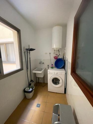 baño pequeño con lavadora y lavamanos en La Guarida de Alcalán en Alcalá