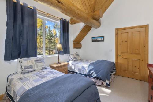 two beds in a room with a window at Sneffels in Telluride