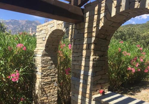 un pont en briques avec des fleurs roses en arrière-plan dans l'établissement A Furtezza, à Soveria