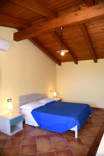 a bedroom with a blue bed and a wooden ceiling at B&B Villa Del Regno in Centola
