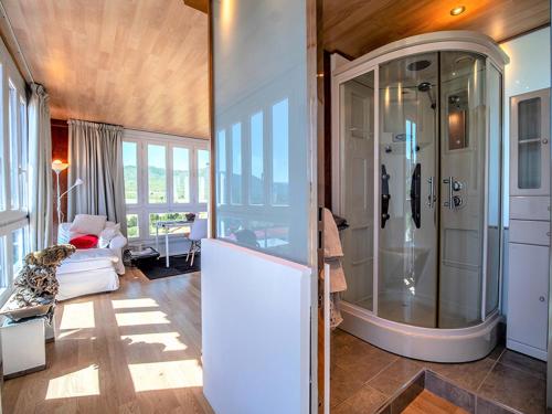 a bathroom with a shower and a living room at Casa Poniente - Casa Rural Los Cuatro Vientos in Moratalla