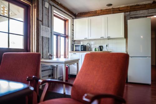 a kitchen with two chairs and a white refrigerator at Matkustajakoti Ykspihlaja in Kokkola